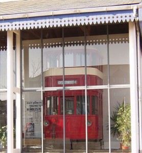 Window of the Tramshed with the front of the Mumbles train visible behind the glass.